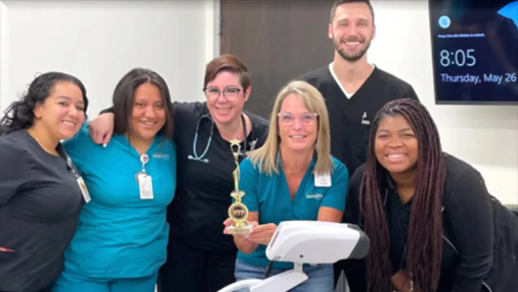 Honor Health logo and a group of healthcare professionals holding a trophy